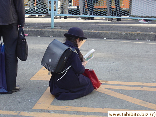 A primary school student waiting for the bus
