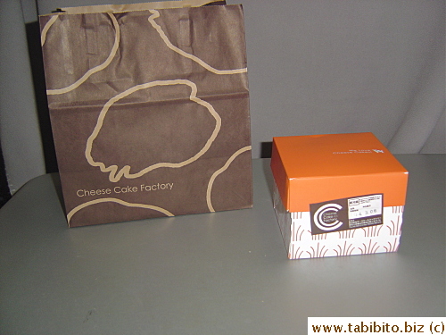 One tiny piece of cheesecake comes in its box and a medium-sized shopping bag