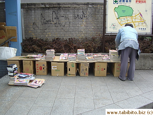 Setting up shop. These people collect comics from recycle bins and trains left by passengers and sell them for 100 yen a piece