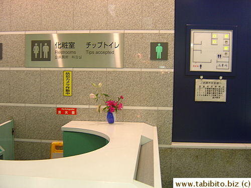 A panel of lights outside this restroom in Shinagawa station tells people which stalls are vacant and there is a slot at the desk for people to drop tips, the very first time I ever saw this custom solicited in Japan