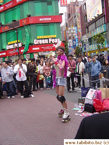 He's selling CDs on the street, but what's the roller skates for? Perhaps easy to flee when cops come?