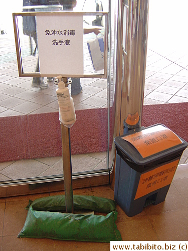 Disinfectant liquid just inside the hospital, the bin next to it is for discarded masks