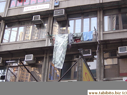 Clothes drying HK style, but freshly washed sheet gets dirty the moment it's hung brushing past the dirty awning