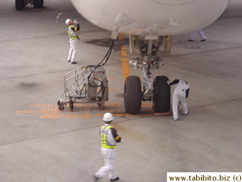 As soon as a plane finishes taxiing and parked in its bay, mechanics rush to check it