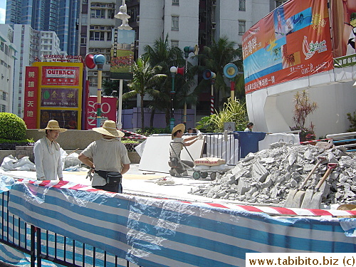 Construction workers don straw hats for protection from the sun