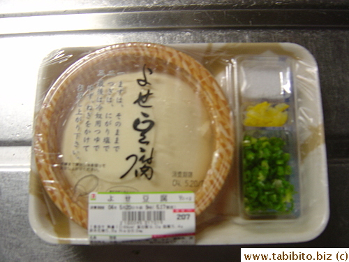 Cold tofu side dish. It comes with salt, graded lemon peel, chopped green onions and sauce.  