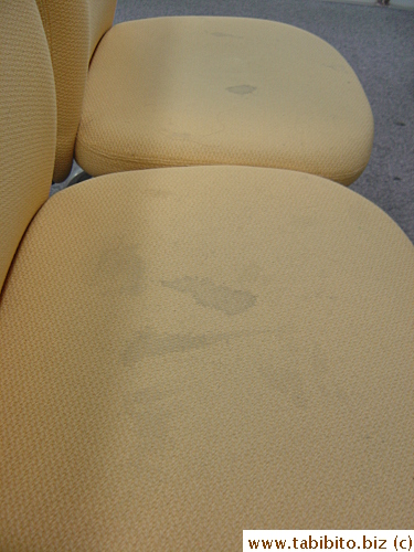 There are many plush seats for people waiting their turns to see the officers in the visa application section, but most have stains on them
