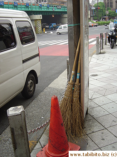 A couple of straw brooms on a busy street in Shinjuku