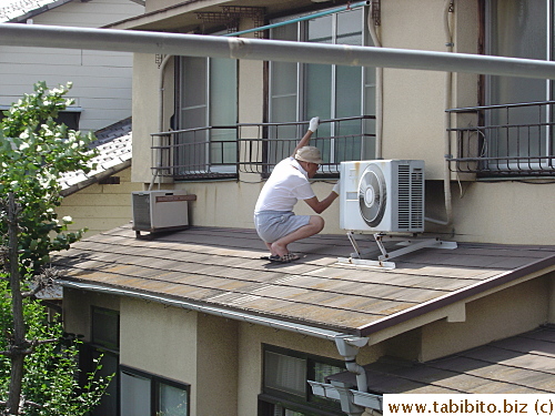 Our neighbor across the street repaints the railings. Wearing slippers on a slanted rooftop isn't such a good idea