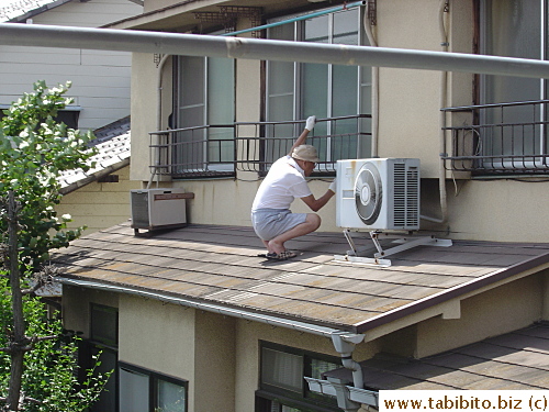 Our neighbor across the street repaints the railings.  Wearing slippers on a slanted rooftop isn't such a good idea