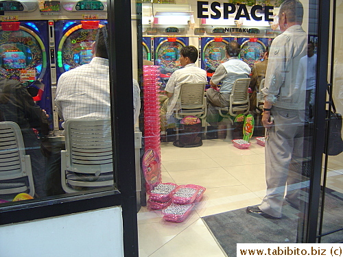 The silver balls a player wins are always stacked up in pink containers next to him on the floor