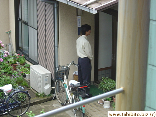 One staff has gone inside the house while the other one just bows continuously at the door