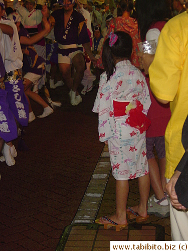 You can always find yukata-wearing women among the spectators in a matsuri.  Unlike the adult version which is full-length, kids' yukata is sometimes knee-length like this girl's