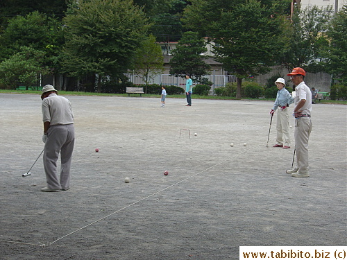 Three people enjoying a game of croquet in one of the parks we cycle past