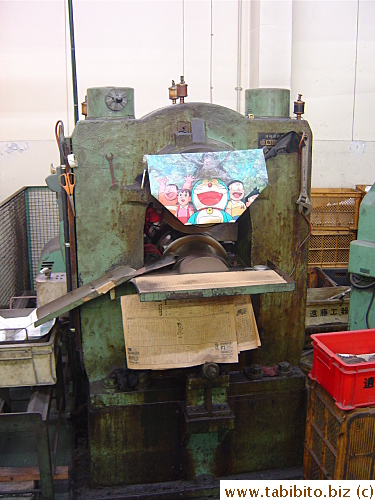An old Doraemen poster decorates one of the spoon-making machines