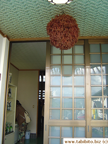 The staff hangs a green plant outside the entrance of the sake brewery when they make a new batch of sake, when the plant turns brown, the sake will have finished aging