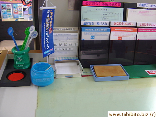 A counter in our local post office.  An ink pad is provided for customers to stamp their documents with name seals, a standard procedure in Japanese society