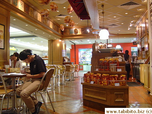 A staff in the caf� working on something on one of the tables