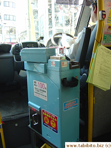 The fare box inside the bus (the driver is properly dressed with hat, gloves, and microphones as always)