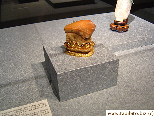 A piece of brown color jade carved to look like a chunk of belly pork