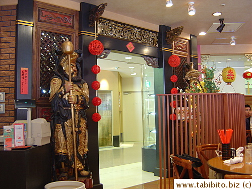 A pair of figures from the Chinese myth guard the entrance of the restaurant
