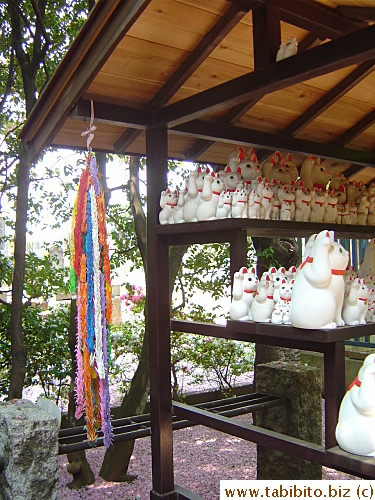 Strings of paper cranes accompany the maneki neko