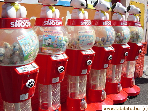 A row of Snoopy toy vending machines outside the store
