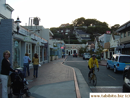 Sam's Café is the blue building past the stone pot plants on the left side of this street