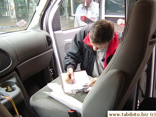 The driver of our shuttle bus writing up a credit card charge for a passenger