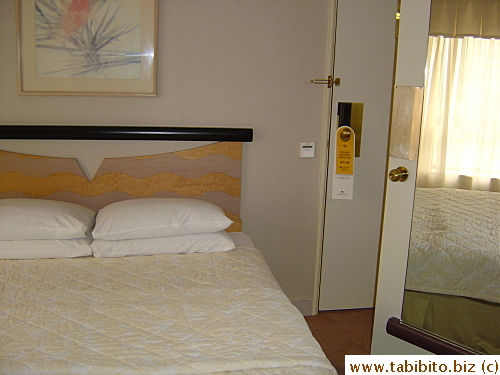 Our hotel room has the poorest furniture arrangement I ever saw. The bed is so close to the door that there's no room for even a smallish bedside table (very inconvenient!) and the mirrored door is the partially-opened bathroom door