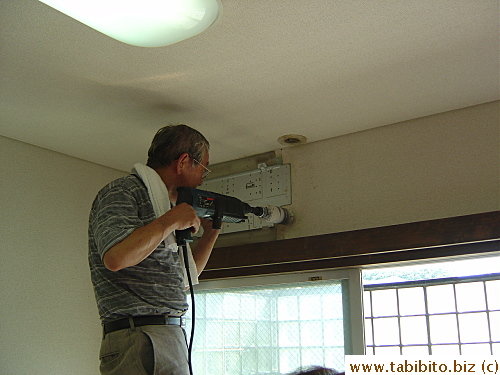 The electrician installs the plate which anchors the new air-con