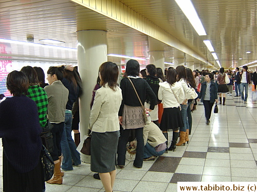 Long stretch of people (women) waiting to get their buttons