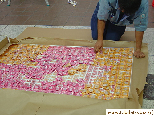 Workers pinning buttons on poster sheets to be hung on the wall