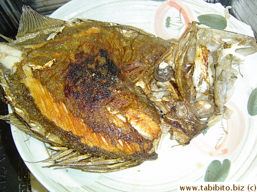 The fried fish is removed from the wok
