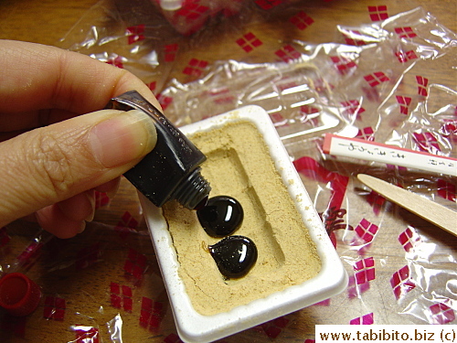 To eat the mochi, dark syrup is squeezed over the soybean flour that covers the mochi