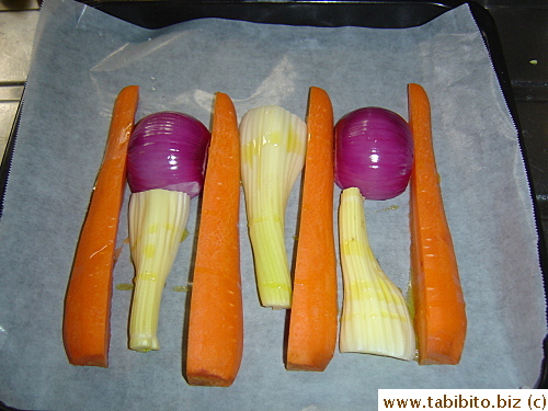 The roasting pan is lined with carrots, celery and onion for the turkey to rest on