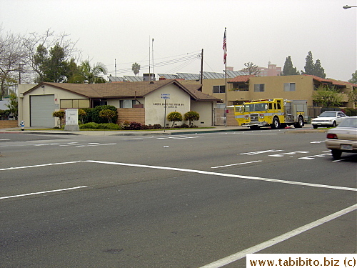A yellow fire truck in front of a fire station