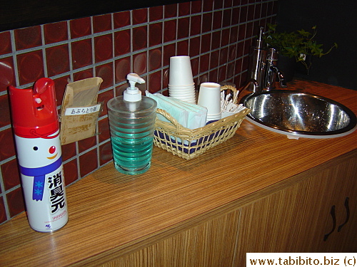 Hannodaidokoro's bathroom is the most well-stocked I've seen.  The can on the left is for refreshing the air after a smelly job, the brown paper next to it is facial oil absorbent paper.  There's even a supply of sanitary napkins