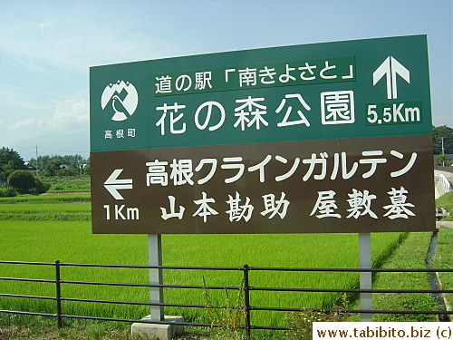 Some rice paddies extend all the way to the road like this one behind the road sign