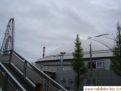 A footbridge connects the station to the complex/area