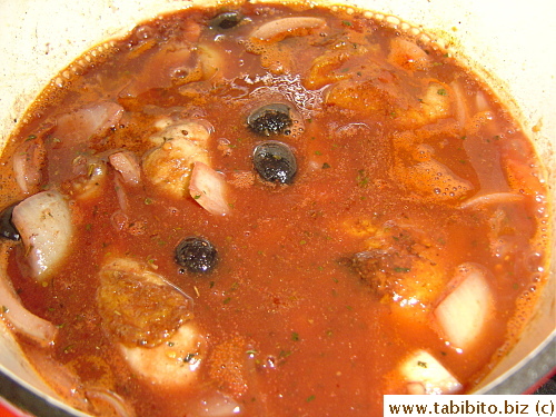 Canned tomatoes and seasonings are added