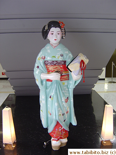 A geisha statue in front of the elevator to the Observatory