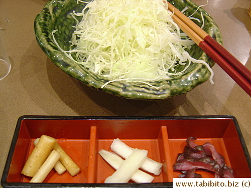 A bowl of cabbage and pickled vegetables arrive before the rest of the set