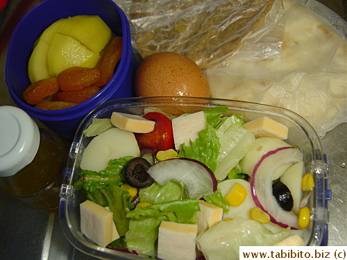 Garden salad with cheese, soft-boiled egg, naan, cookie, kiwi and dried apricot