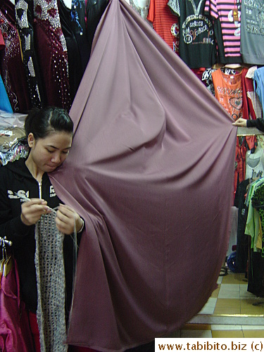 KL's trying on shorts behind this curtain held up by two women