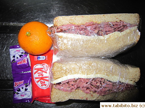 Pastrami and cheese sandwich, KitKat, Ribena candies, mandarin