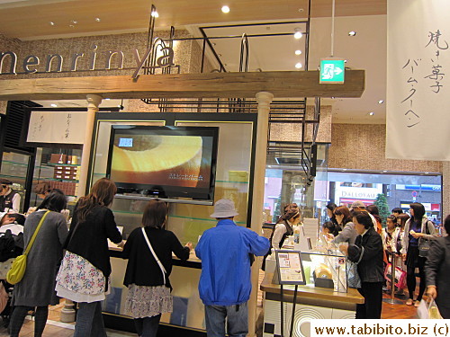 The people under the screen were filling out delivery forms for their purchase