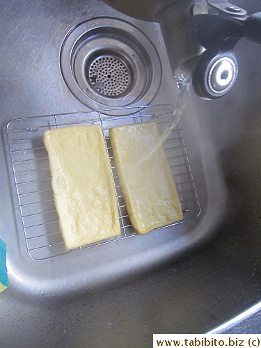 Boiling water poured over fried tofu sheets to remove some grease
