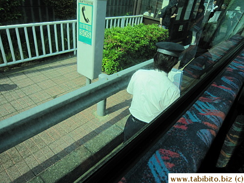 The bus makes stops on the highway and the driver gets out to check boarding passengers' tickets before he climbs back into his seat