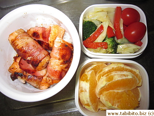 Bacon-wrapped salmon, stirfried vegetables, cherry tomatoes, orange